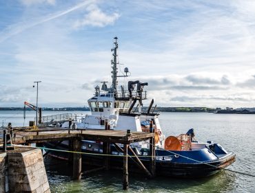 Tugboat moored in the harbour of Cobh, a small irish town near Cork a sunny morning